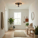 Modern hallway with plants, a bench, and a ceiling light fixture.