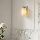 Wall-mounted light fixture on a white paneled wall with marble trim